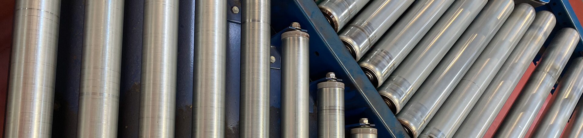 Rouleaux de manutention utilisés sur un convoyeur industriel